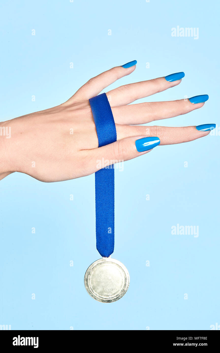 Close-up of woman's hand holding a medal Stock Photo