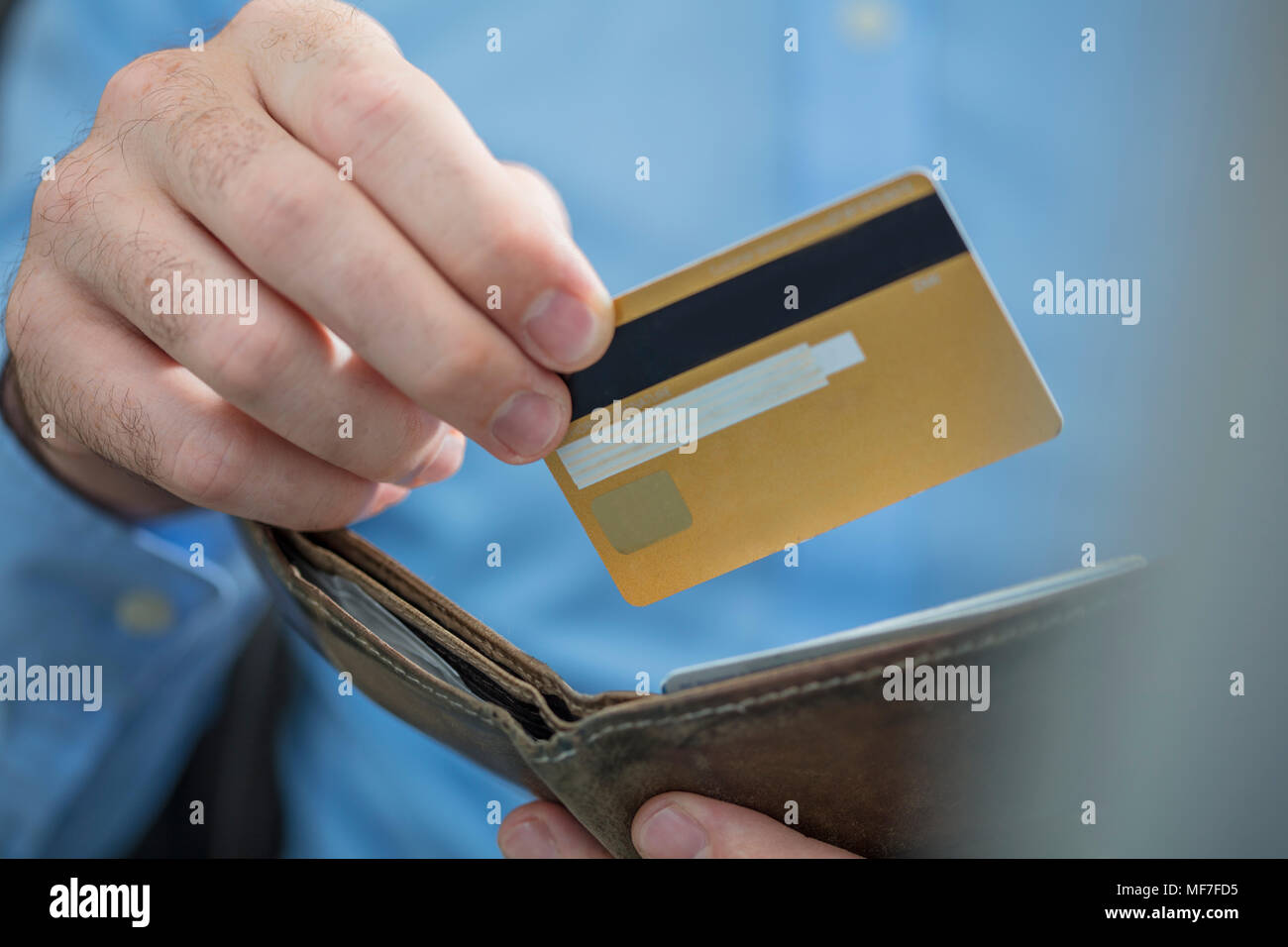 Man's hands holding credit card and purse, close-up Stock Photo