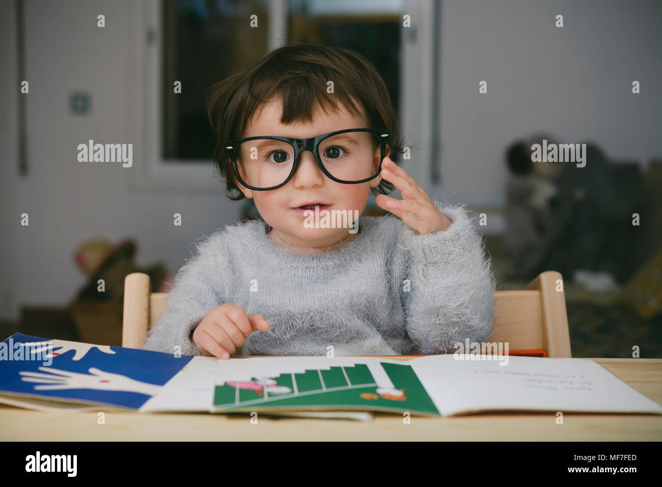 Portrait of relaxed baby girl wearing oversized glasses Stock Photo