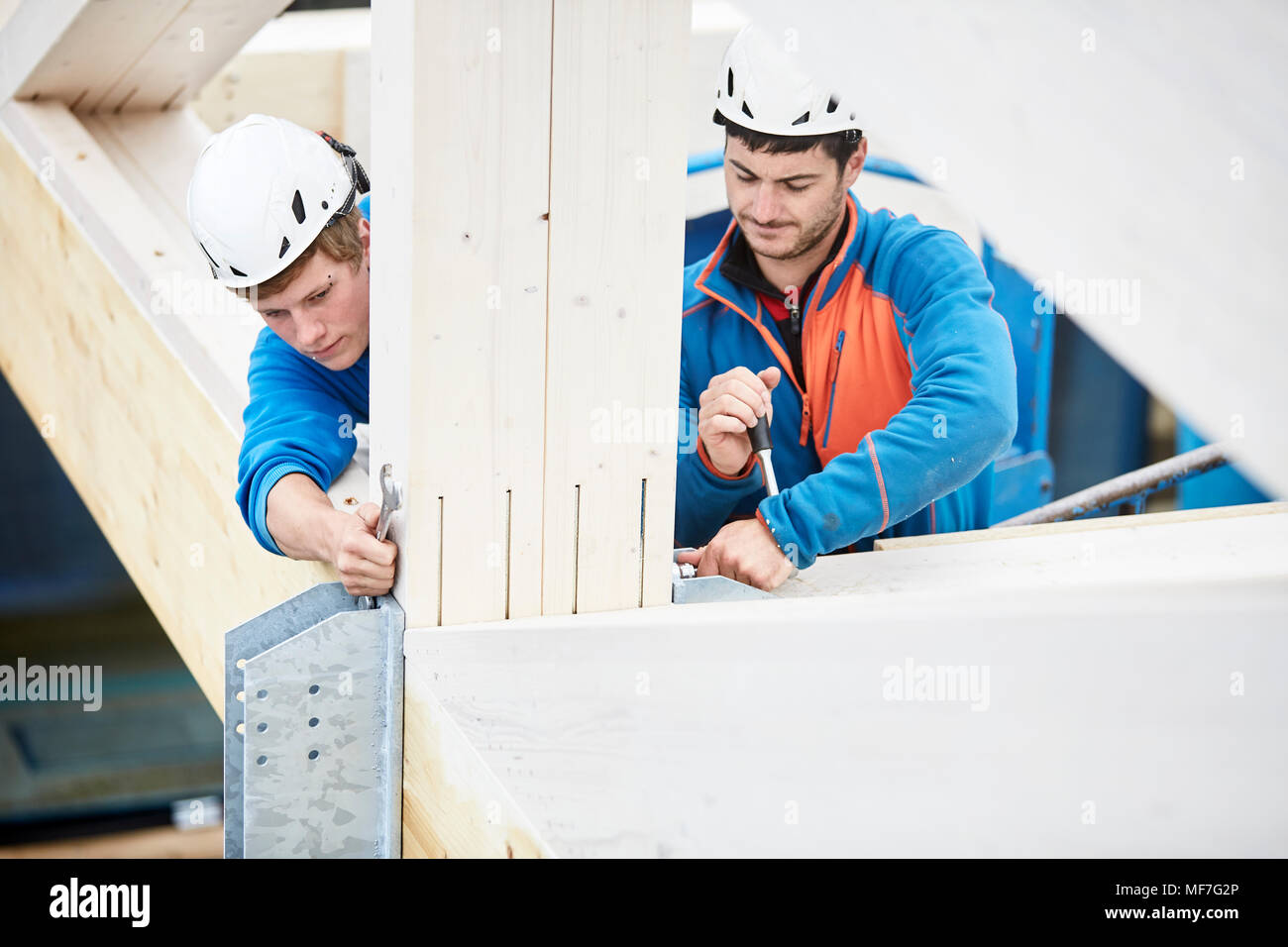 Austria, workers fixing roof construction Stock Photo