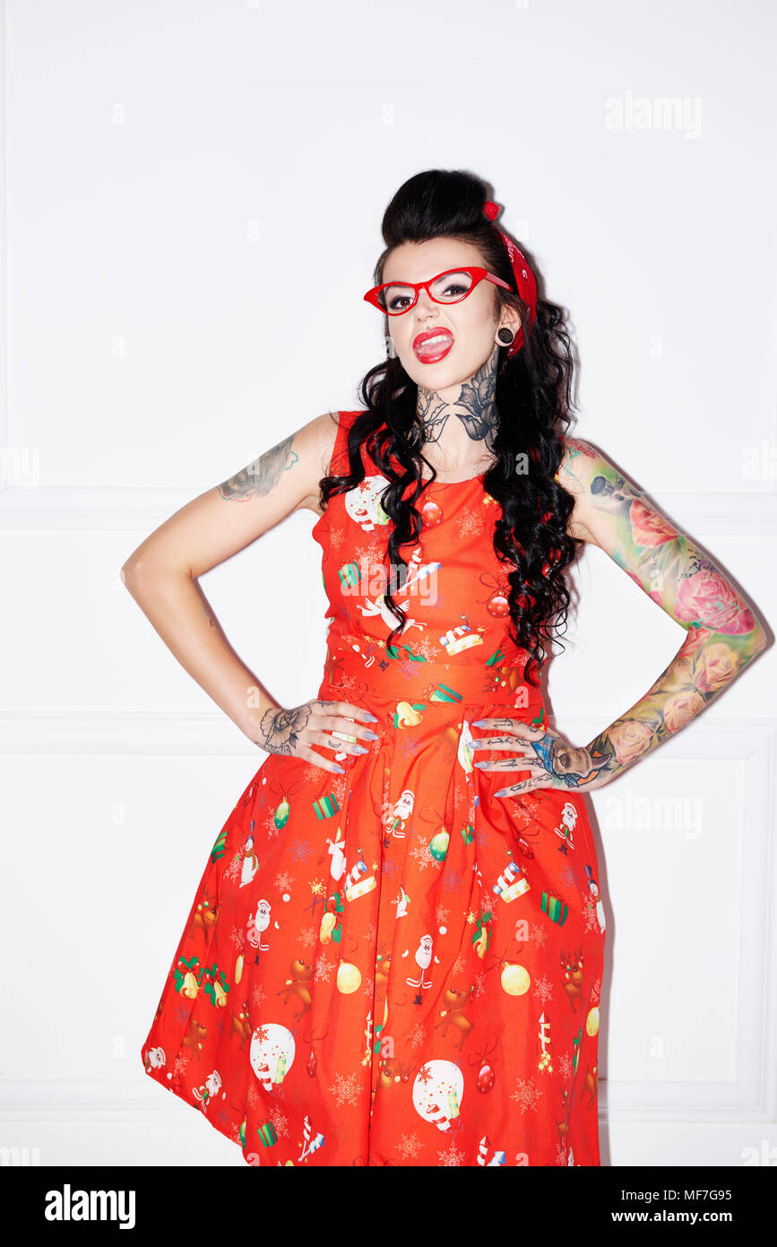 Portrait of tattooed woman wearing patterned red dress Stock Photo