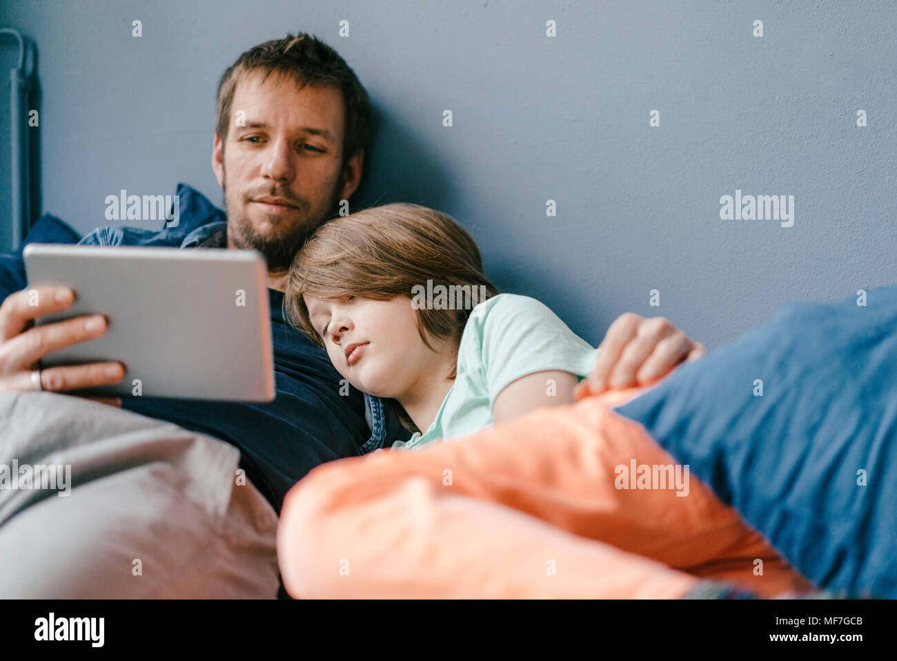 Father and son watching a movie on tablet at home Stock Photo