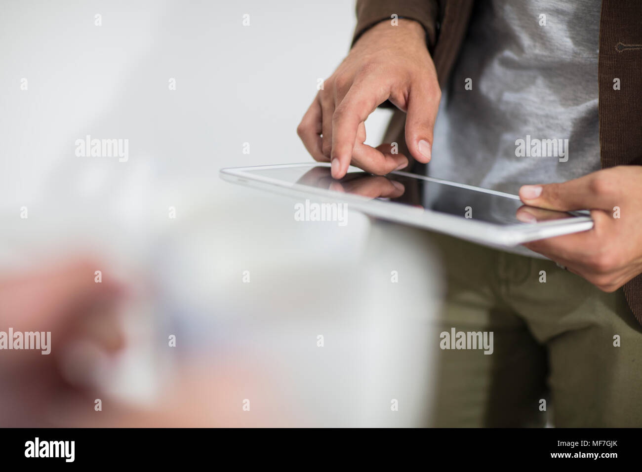 Close-up of man using tablet in office Stock Photo