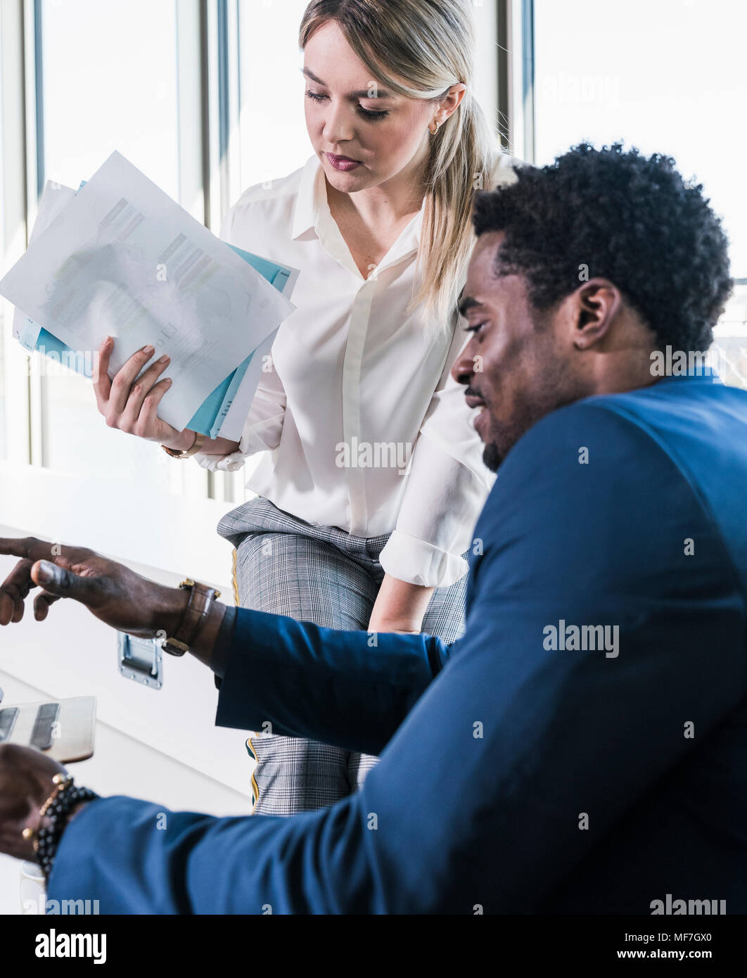 Businesswoman and businessman discussing papers Stock Photo