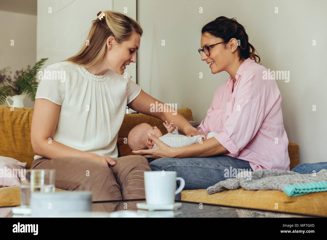 Midwife and mother giving newborn baby a belly massage to help with
