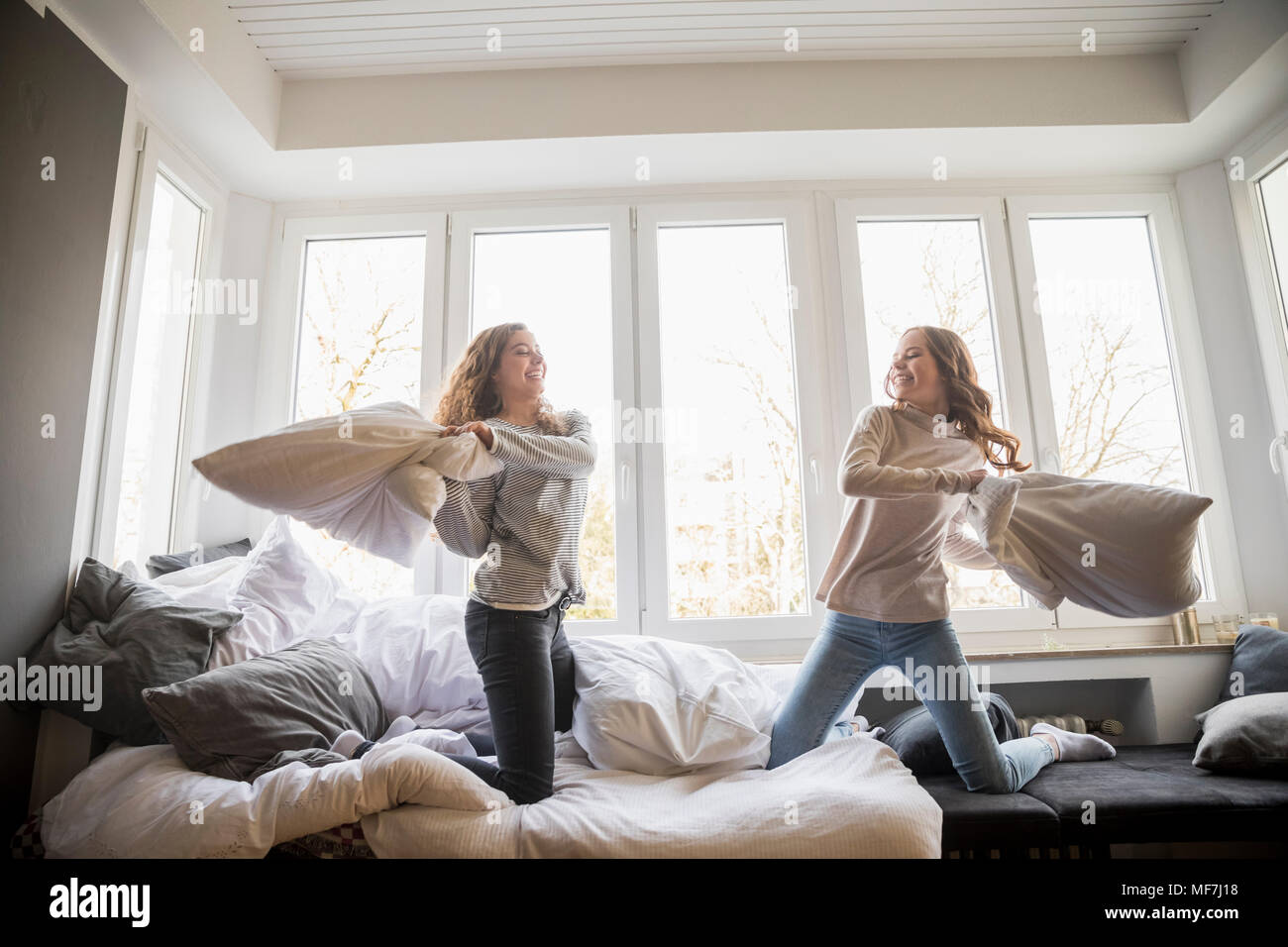 Pillow fight between two best friends at home Stock Photo