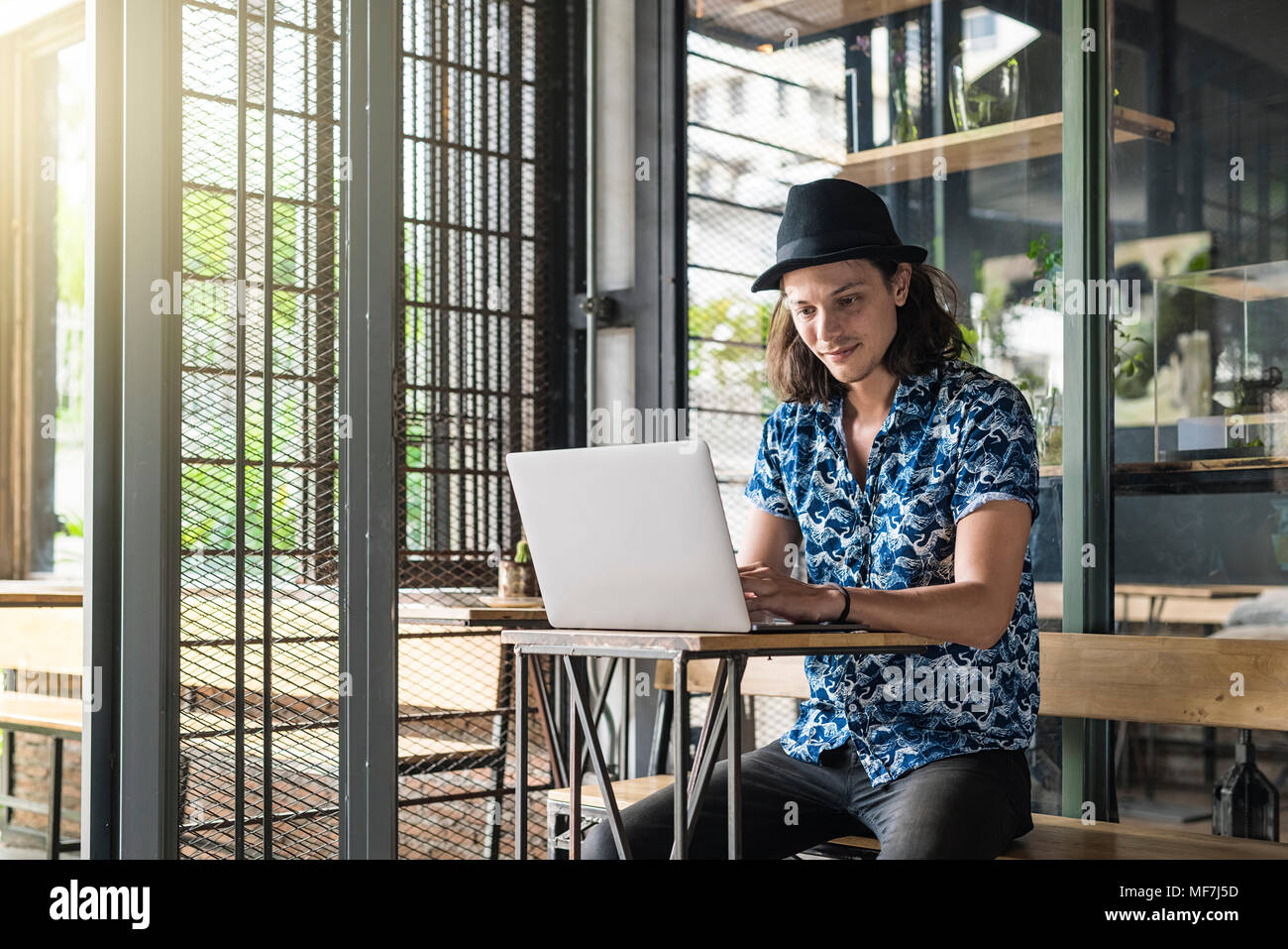 Artist sitting in a cafe  and typing on laptop Stock Photo