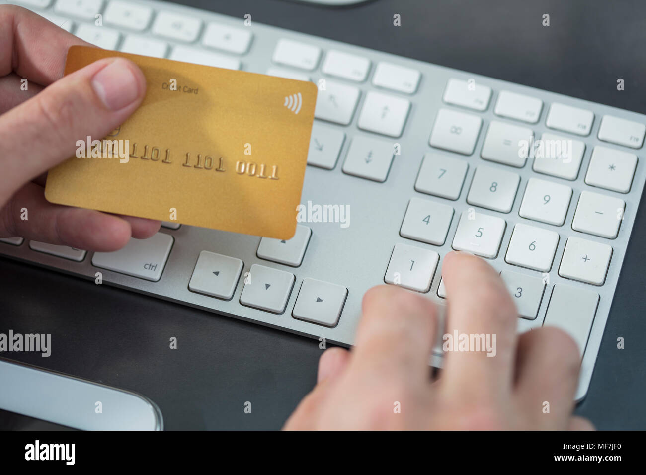 Man making online payment with credit card at desk, close-up Stock Photo