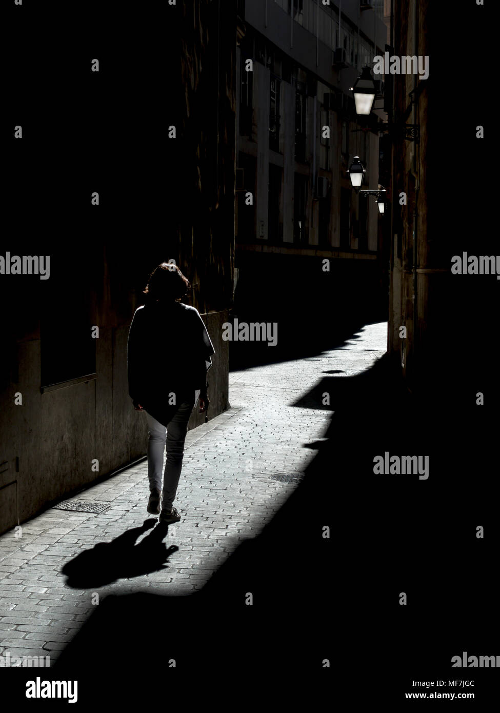 Spain, Palma de Mallorca, woman walking in alley Stock Photo