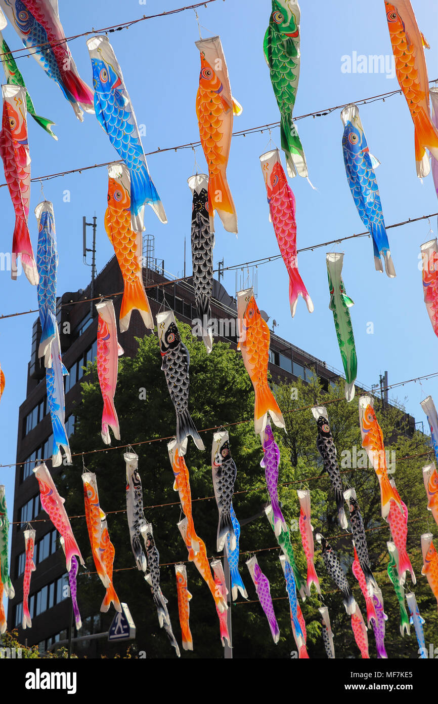 Many colorful paper carp or fish-shaped lanterns,called koinobori, hang on  ropes strung diagonally overhead against a blue sky. Sunlight strikes them  Stock Photo - Alamy