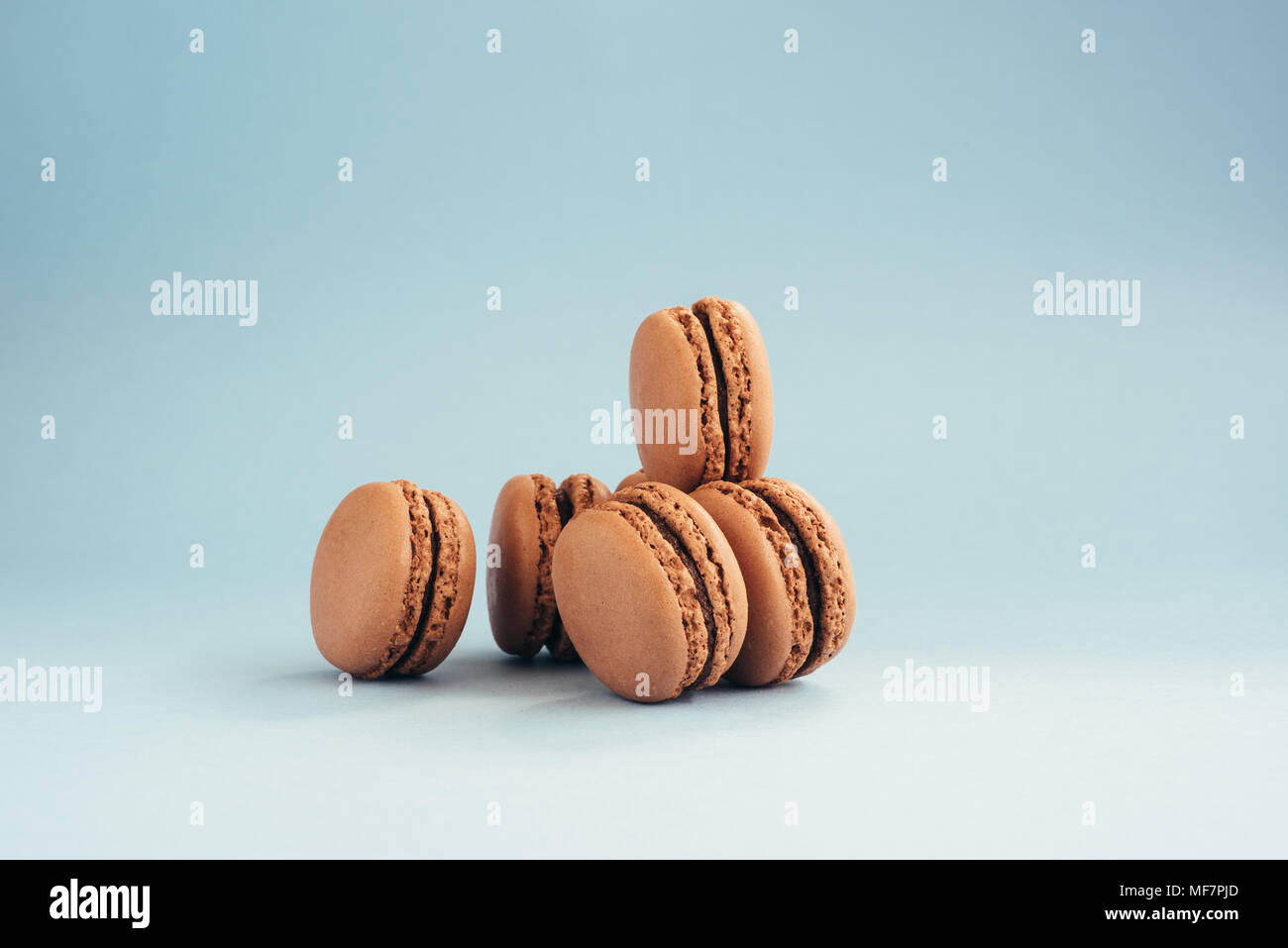 Chocolate macarons isolated on a blue background. Stock Photo