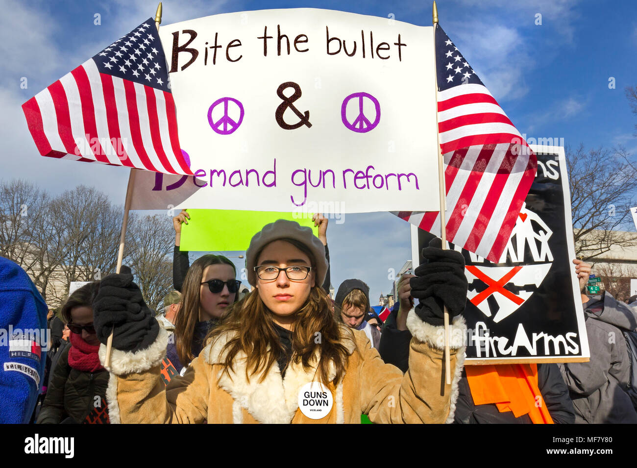 Young female student holding protest sign with American flags. March For Our Lives rally against gun violence on March 24, 2018 in Washington, DC. Stock Photo