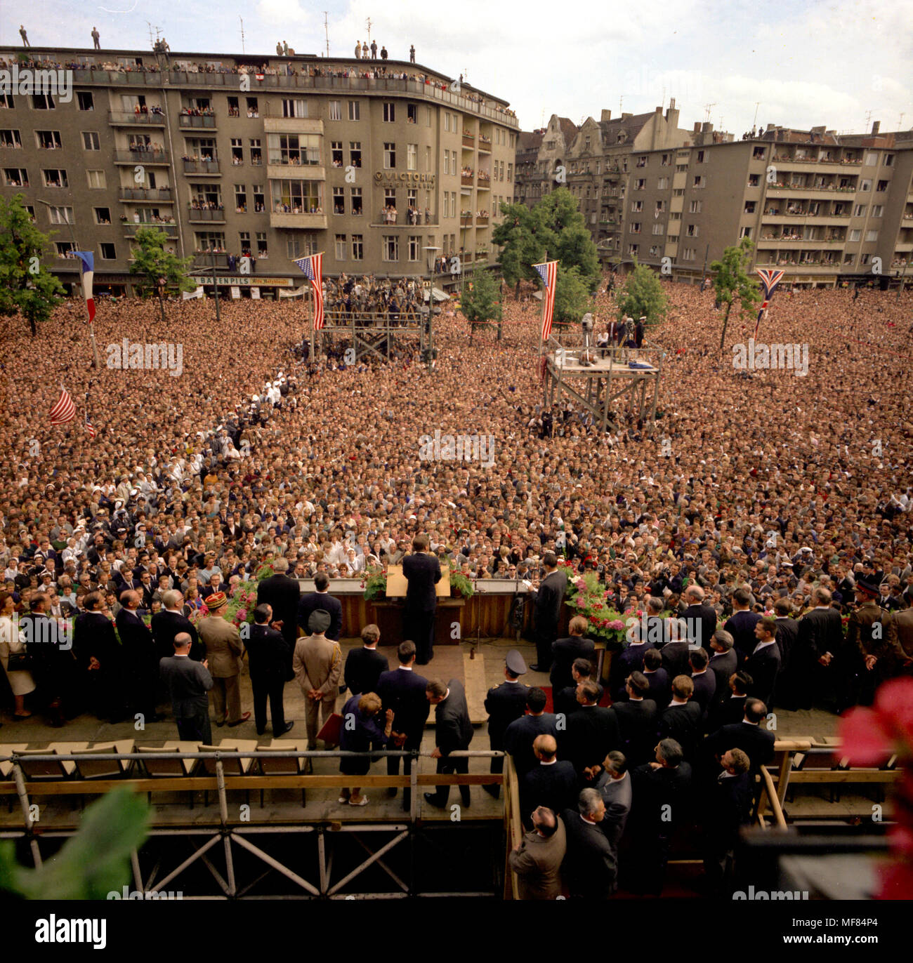 KN-C29248  26 June 1963  President John F. Kennedy delivering an address in West Berlin. Photograph is a rear view of President Kennedy and others on podium and shows the large crowd and cameramen viewing the address. Rathaus, West Berlin, Germany.   Please credit: Robert Knudsen, White House/John F. Kennedy Presidential Library and Museum, Boston. Stock Photo