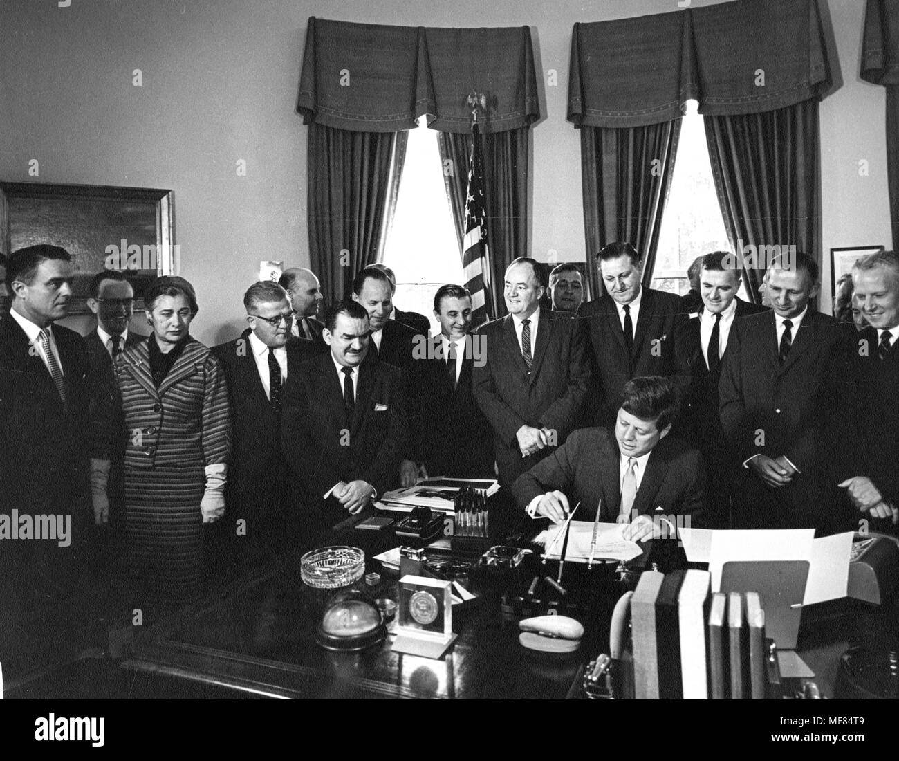 AR6801-B             22 September 1961  President John F. Kennedy signing the Peace Corps Bill in the Oval Office. Individuals identified in the photograph are John F. Kennedy, Sargent Shriver, Representative Edna Kelly, Senator Hubert Humphrey, and Senator Albert Gore  Please Credit 'Abbie Rowe, White House/John F. Kennedy Presidential Libary and Museum, Boston.' Stock Photo