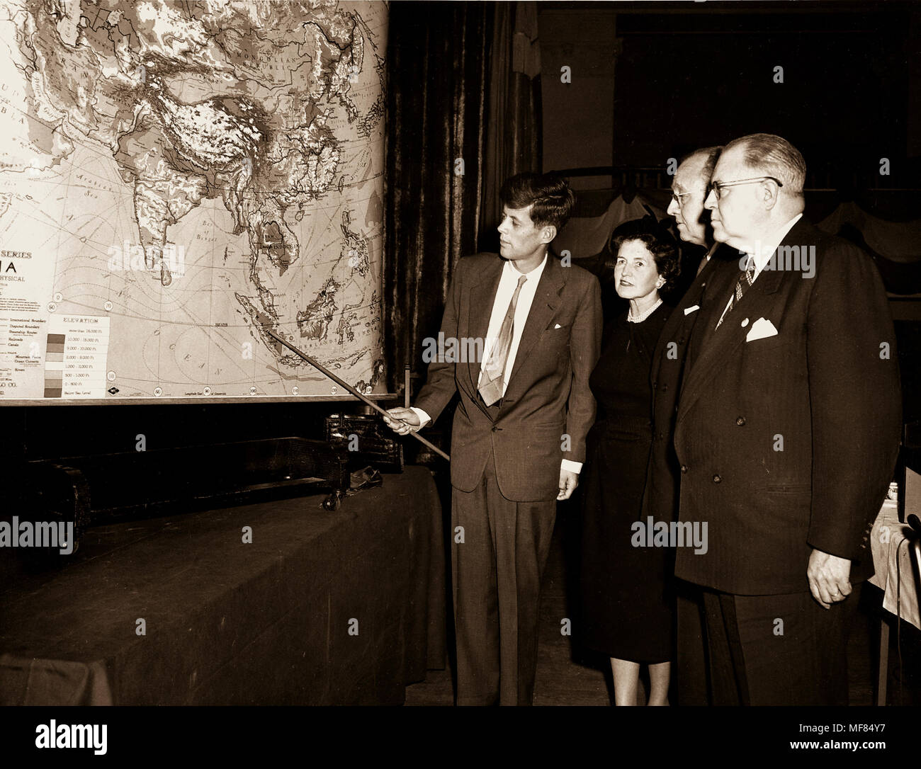 PC435  19 November 1951  John F. Kennedy pointing to a large map during a visit to the Boston Chamber of Commerce for a speech on his tour of Asia and the Near East.  Rose Kennedy and two unidentified men stand to John F. Kennedy's right.   Please credit 'The John F. kennedy Presidential Library and Museum, Bosoton'. Stock Photo