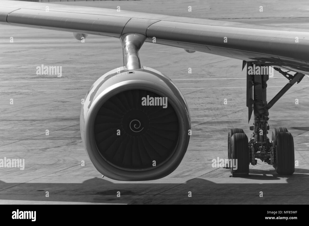 Black and white photo of an airplane engine and a gear with a part o a wing Stock Photo