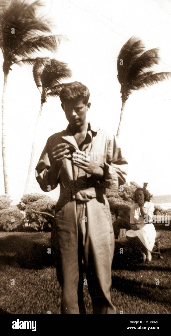 PC 148   John F. Kennedy, Palm Beach, 1944 (note by Eunice Kennedy Shriver, 24 January 1994 - 'Examines coconut Jack sent with message for rescuing in South Pacific'). Please credit 'John Fitzgerald Kennedy Library, Boston'. Stock Photo