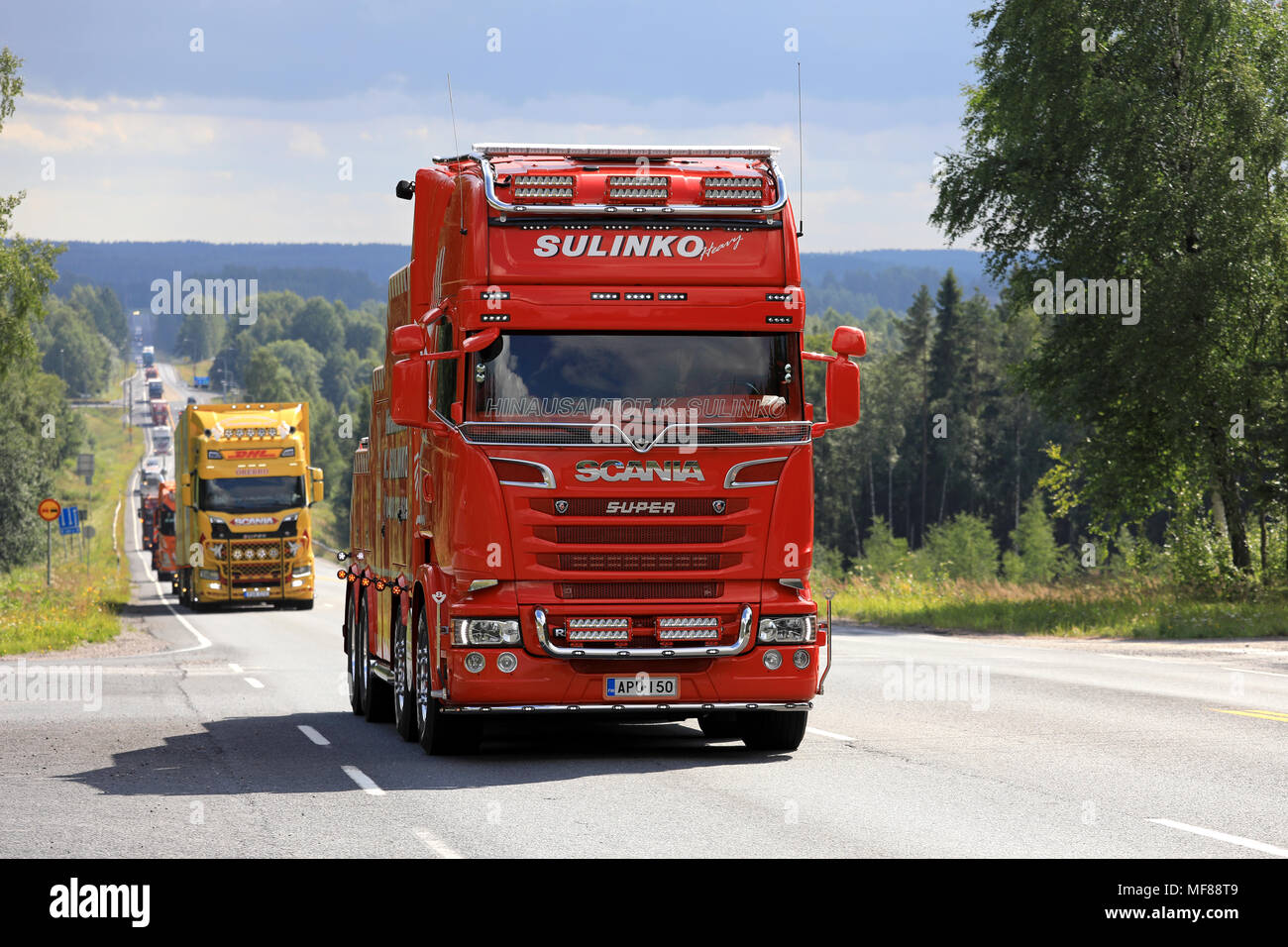 Scania R620 heavy duty tow truck of K. Sulinko leads truck convoy to Power Truck Show along scenic highway in summer in Ikaalinen, Finland - August 10 Stock Photo