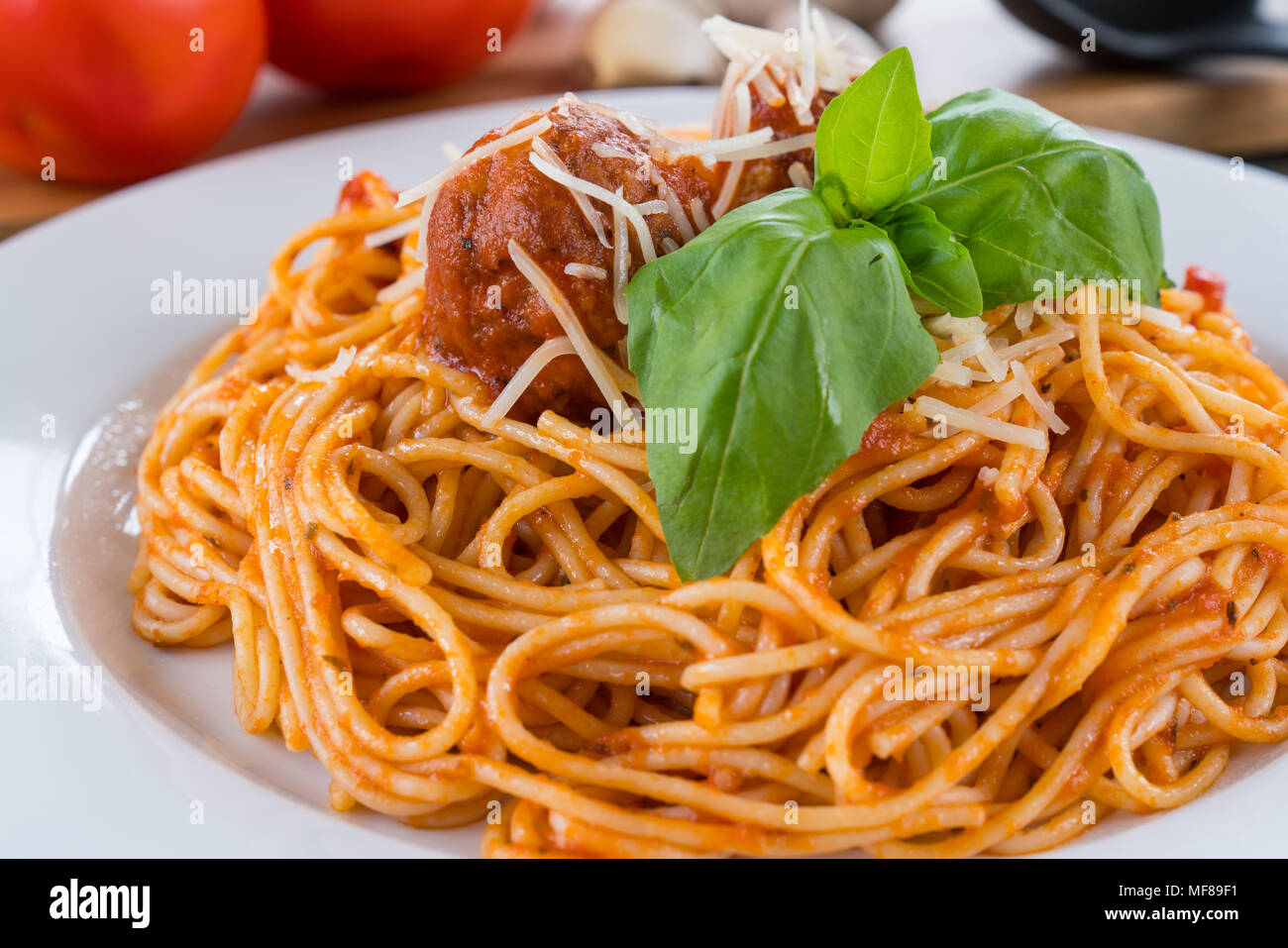 Plate of Spaghetti with tomato sauce, meatballs and Basil Stock Photo