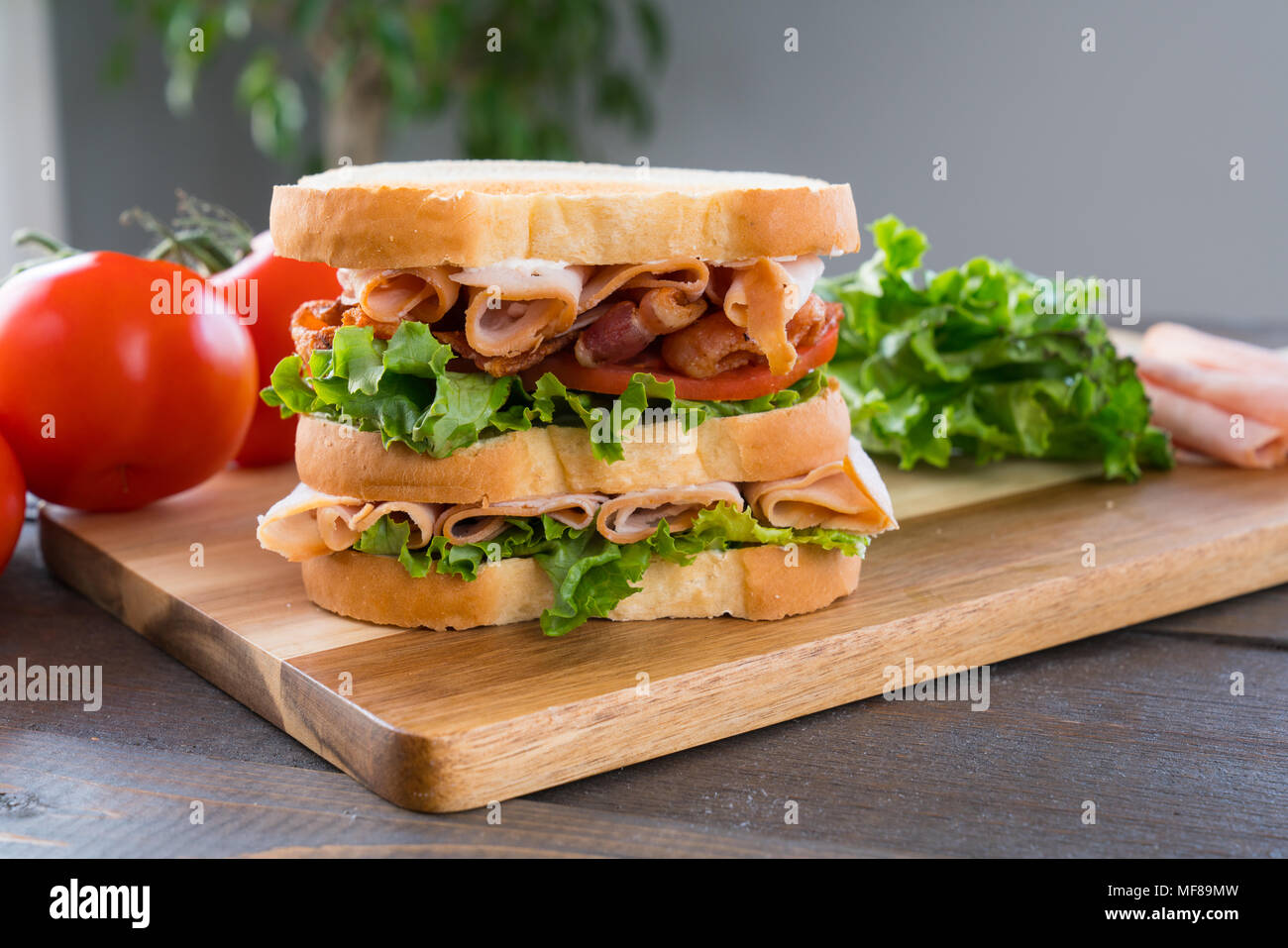 Fresh Triple Decker Turkey Club Deli Sandwich on Cutting Board Stock Photo