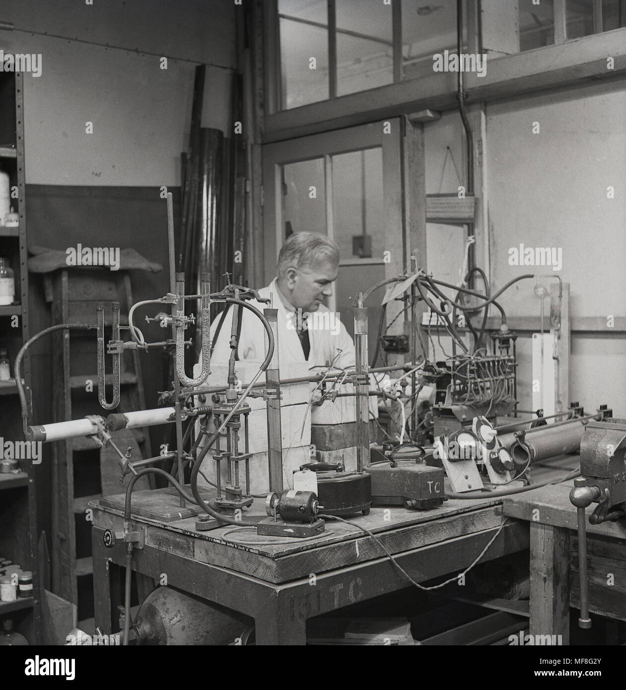 1948, historical, male science chemist at a workbench in laboratory using the apparatus  of the day for his work in researching coal tar - a by-product of burning coal without air - at Leeds University, Dept of Coal, Gas and Fuel industries.  Many commercial compounds are derived from coal tar which belongs to the classification, keratoplastics. Stock Photo