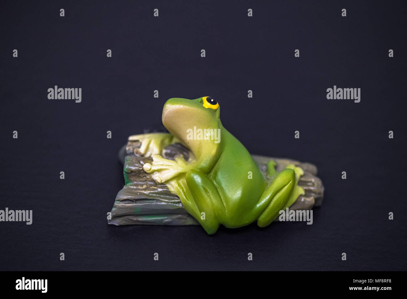 Fridge magnet of a small green frog. Stock Photo