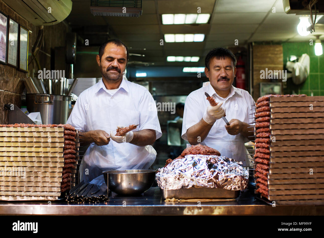 Chefs preparing kebab for the dinner rush. Souq Mubarakiya, Kuwait. Stock Photo