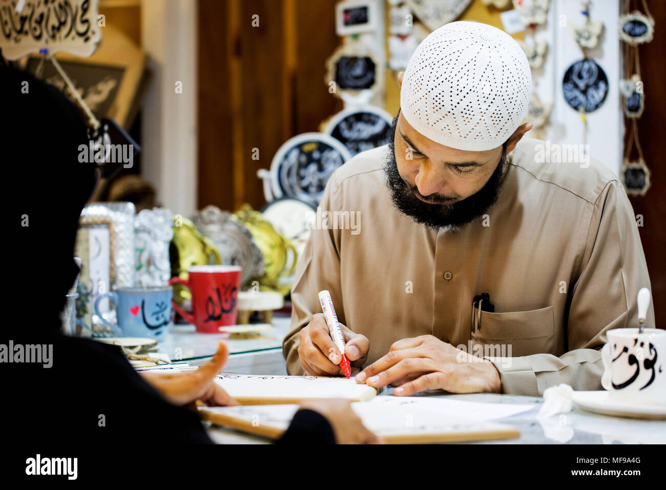 Ceramics being personalised with Arabic script at a souq in Kuwait Stock Photo