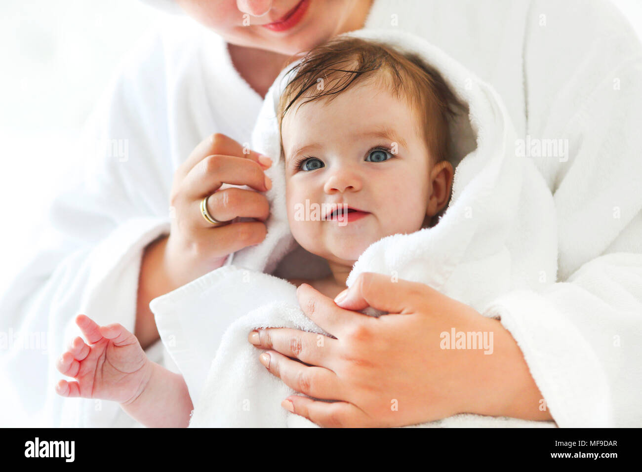 Young woman in the room with baby after bath. Baby care concept Stock