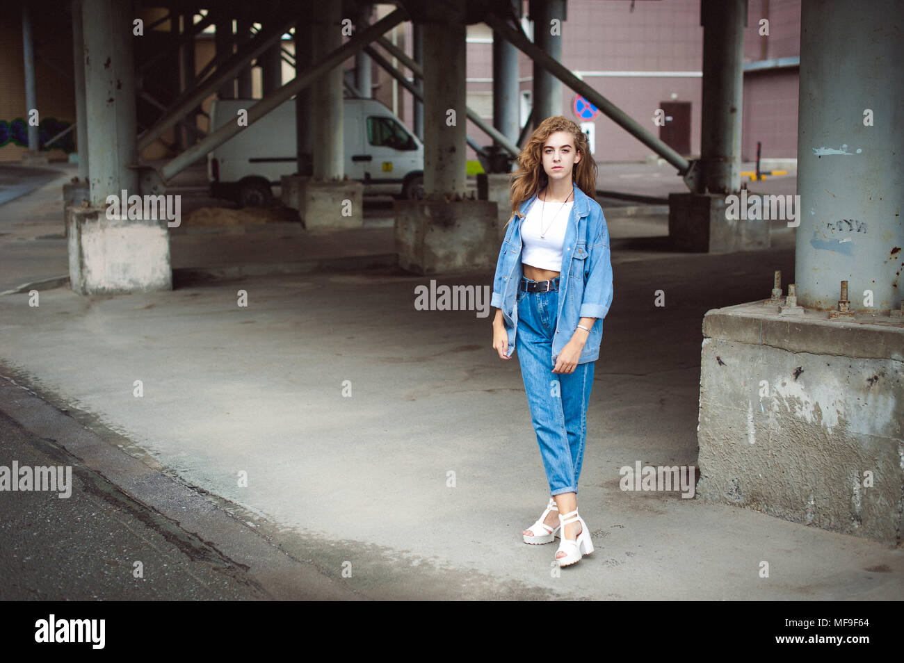 street portrait of a young attractive emotional girl with curly slips  dressed in a trendy blue jeans suit on a style walking in the open air  Stock Photo - Alamy