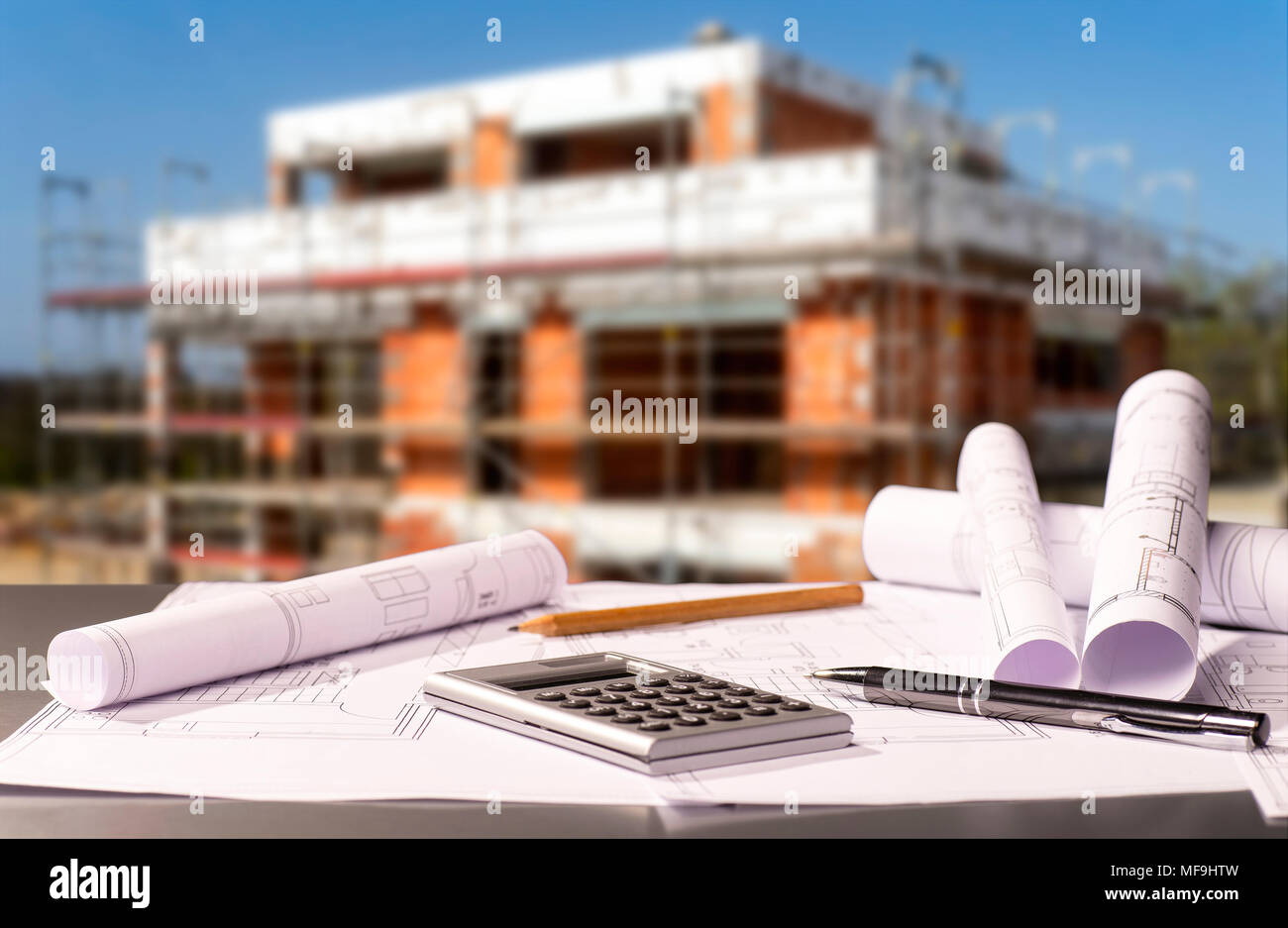 Construction plans with calculator and a shell in the background Stock Photo