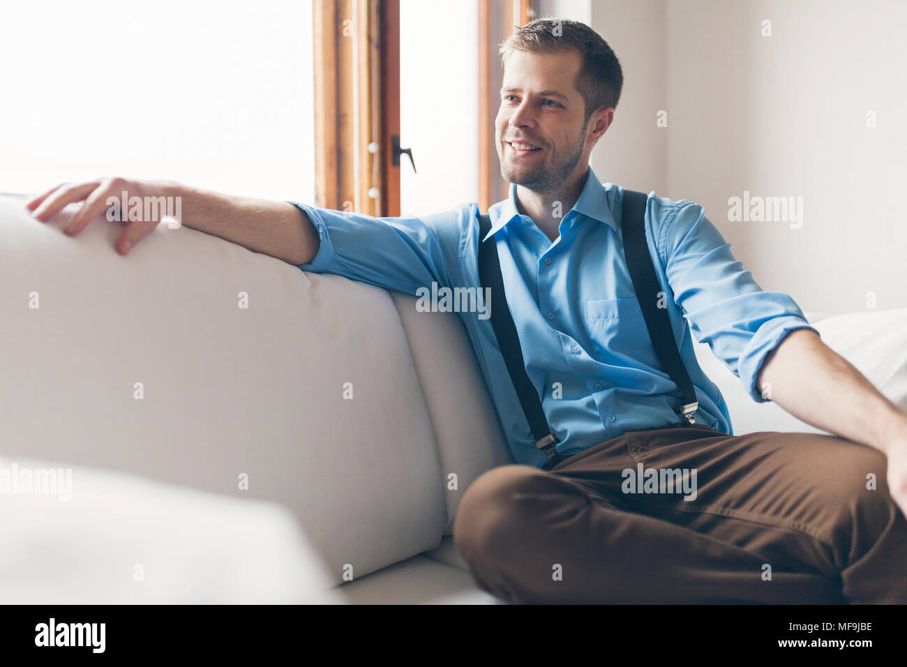 Man sitting and relaxin on sofa at home Stock Photo