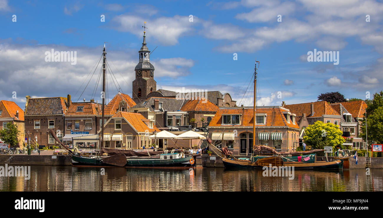 BLOKZIJL, THE NETHERLANDS - JULY 13, 2017: Harbor in the historic village of Blokzijl on sunny summer day with old flat bottom ships and monumental ho Stock Photo
