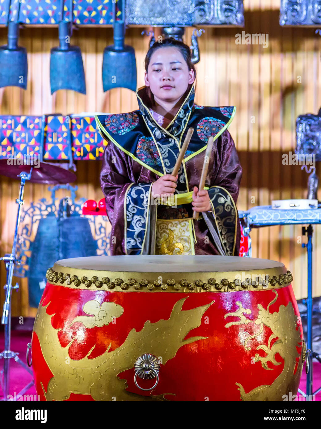 A Chinese girl in a purple kimono plays a large red drum during a  performance at the Drum Tower, Xian, China Stock Photo - Alamy
