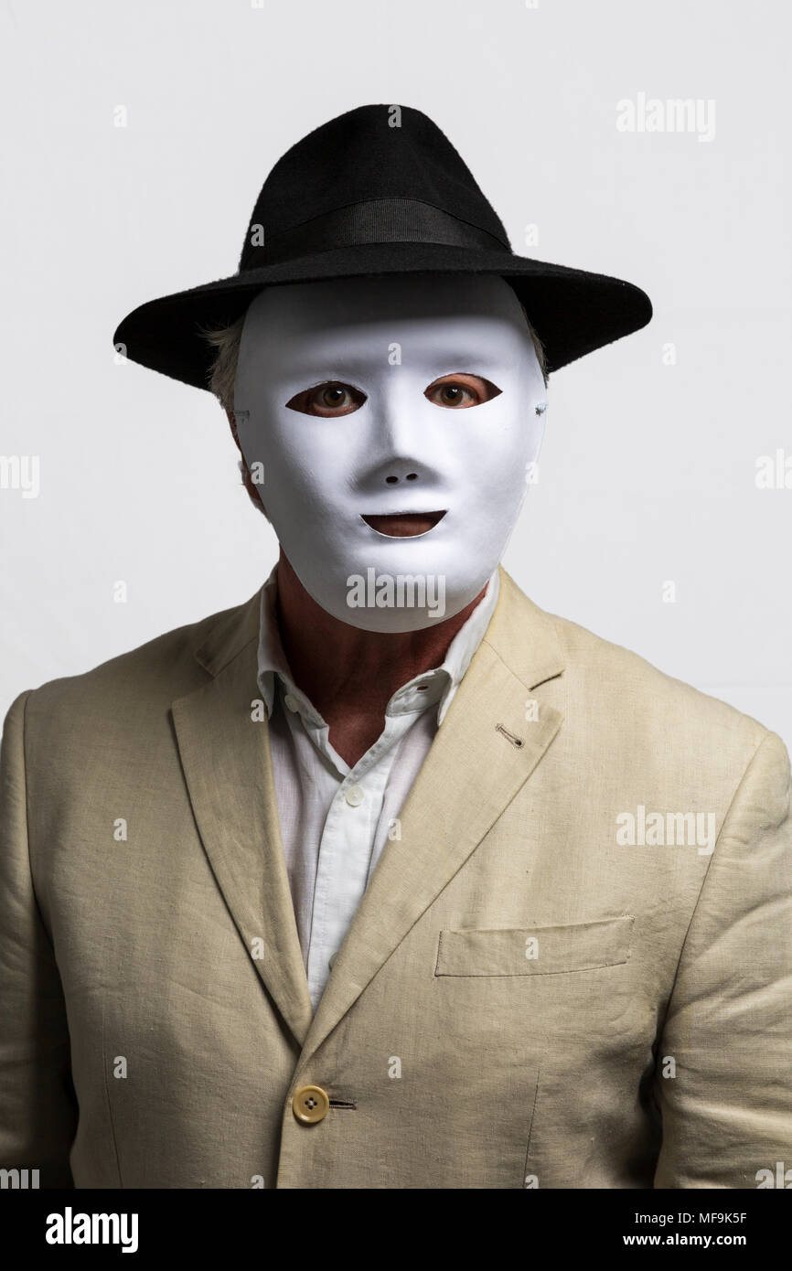Man wearing white face mask, black hat, and linen jacket against white  background Stock Photo - Alamy