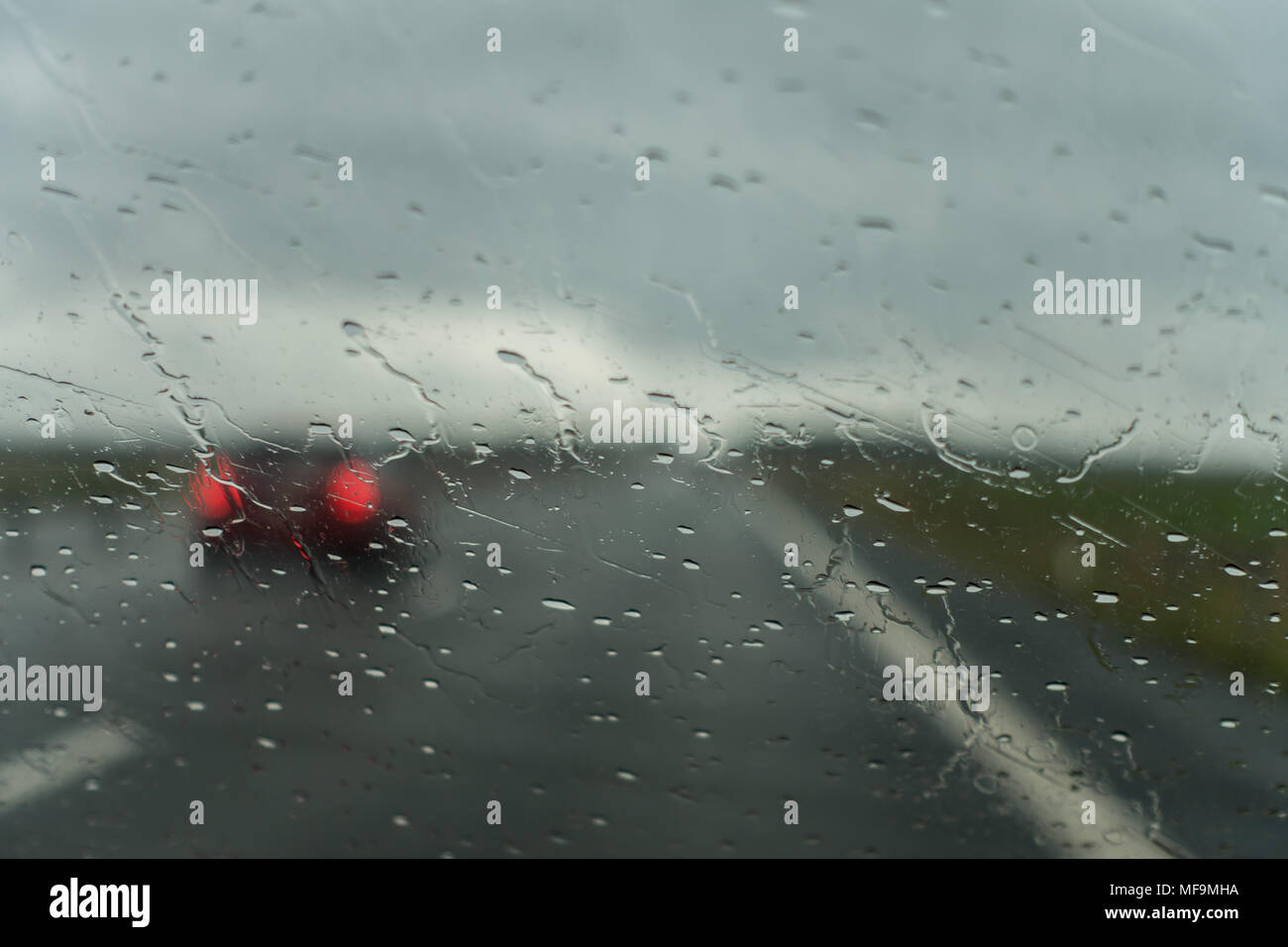 A rainy day on the highway and a car passing by Stock Photo