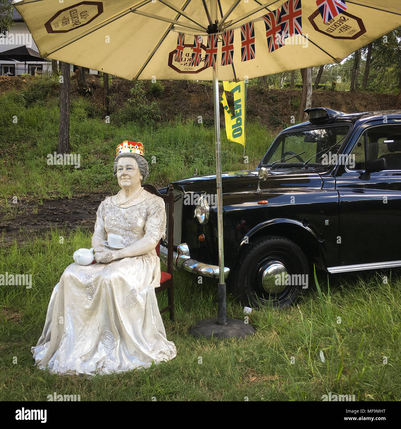 A model of Queen Elizabeth II, and a back London taxi, outside a pub in ...