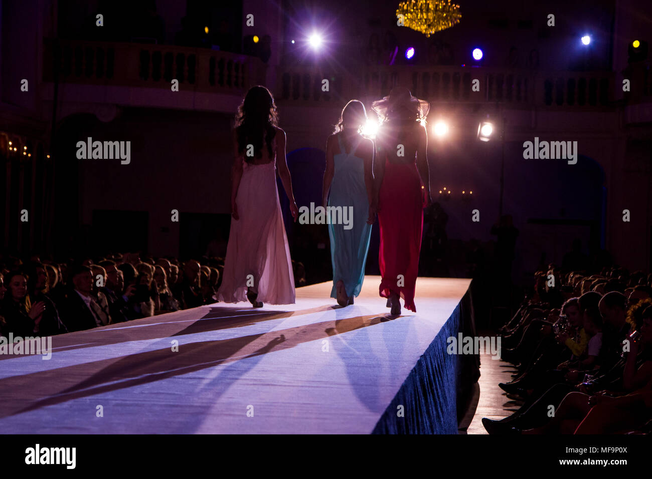 A picture from a fashion show. The models are walking on a catwalk and showing the new clothing. Stock Photo