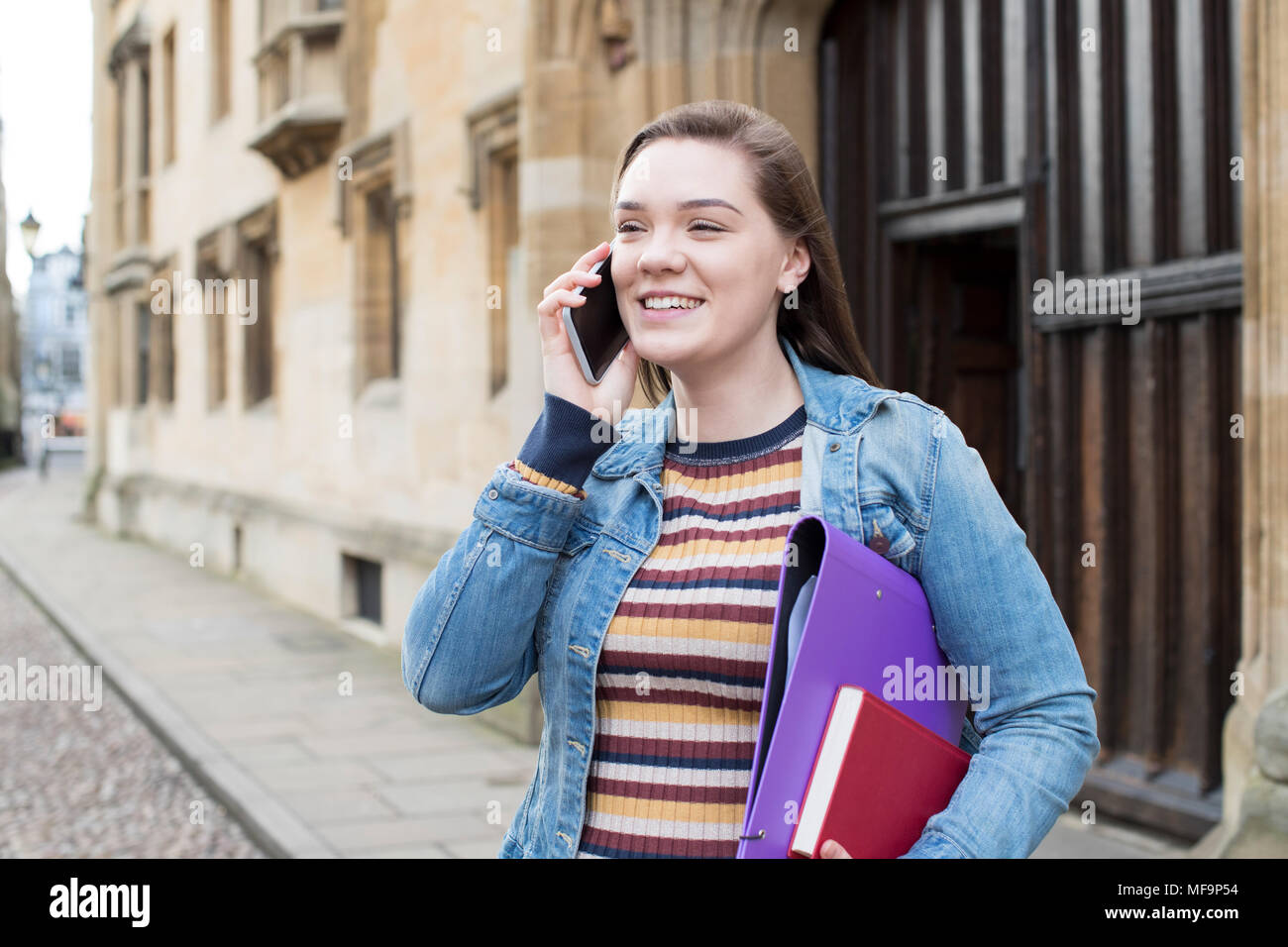 Female Student Talking On Mobile Phone Outside College Building Stock Photo