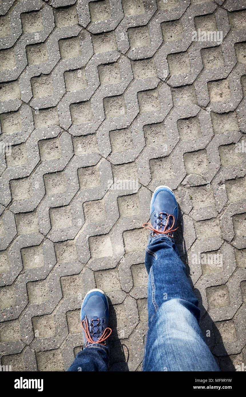 Looking down at blue shoes and jeans while walking Stock Photo - Alamy