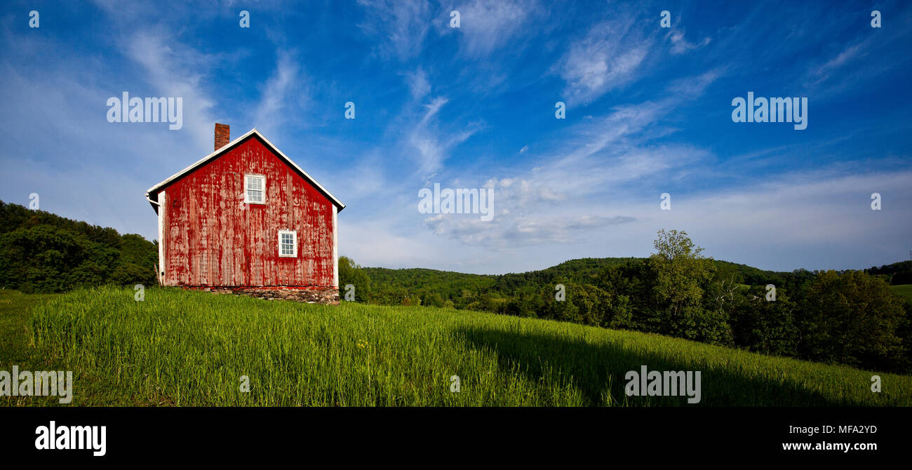 Classic antique red Vermont barn in the beautiful meadow on a summer day Stock Photo