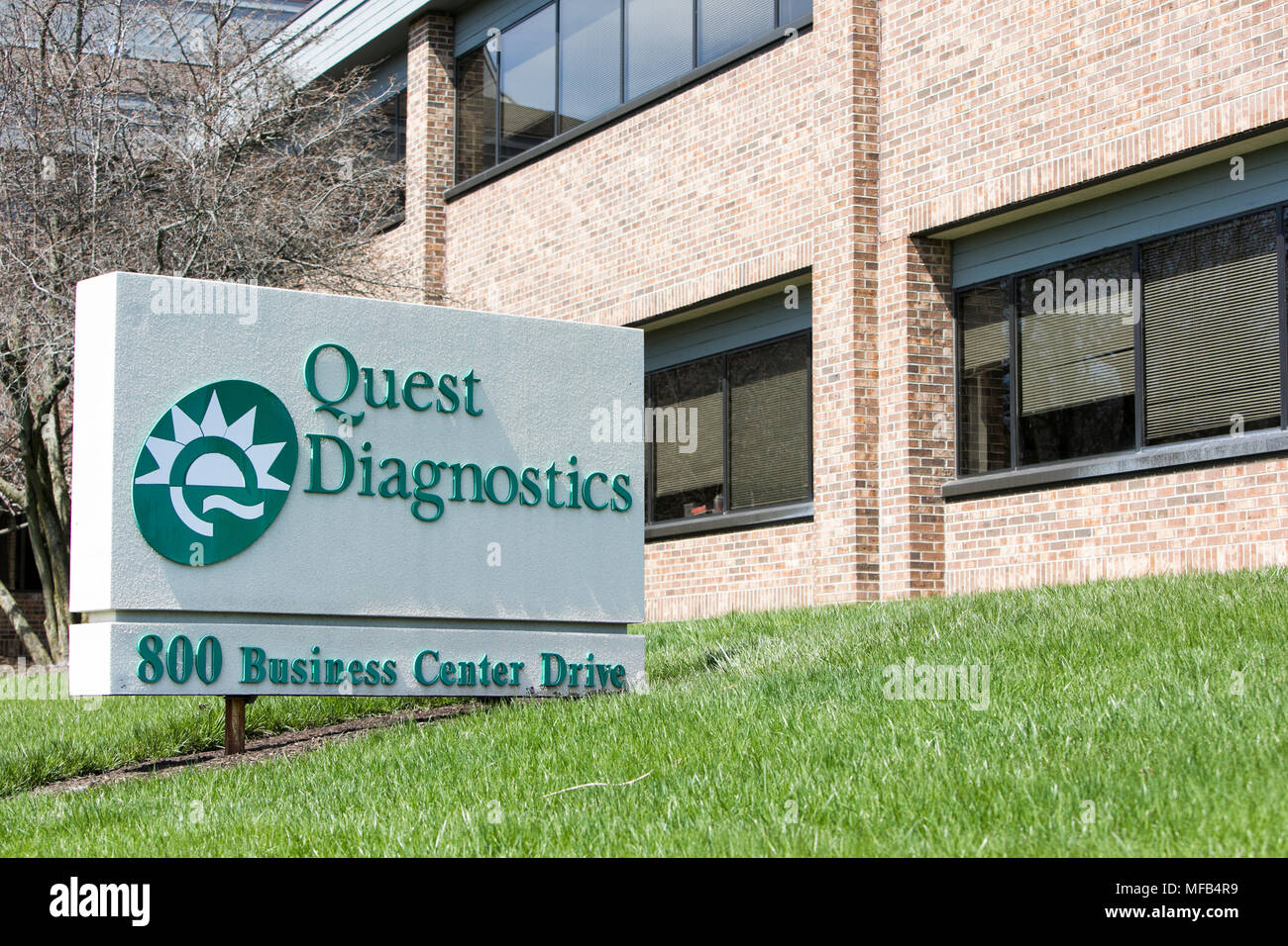 A logo sign outside of a facility occupied by Quest Diagnostics in