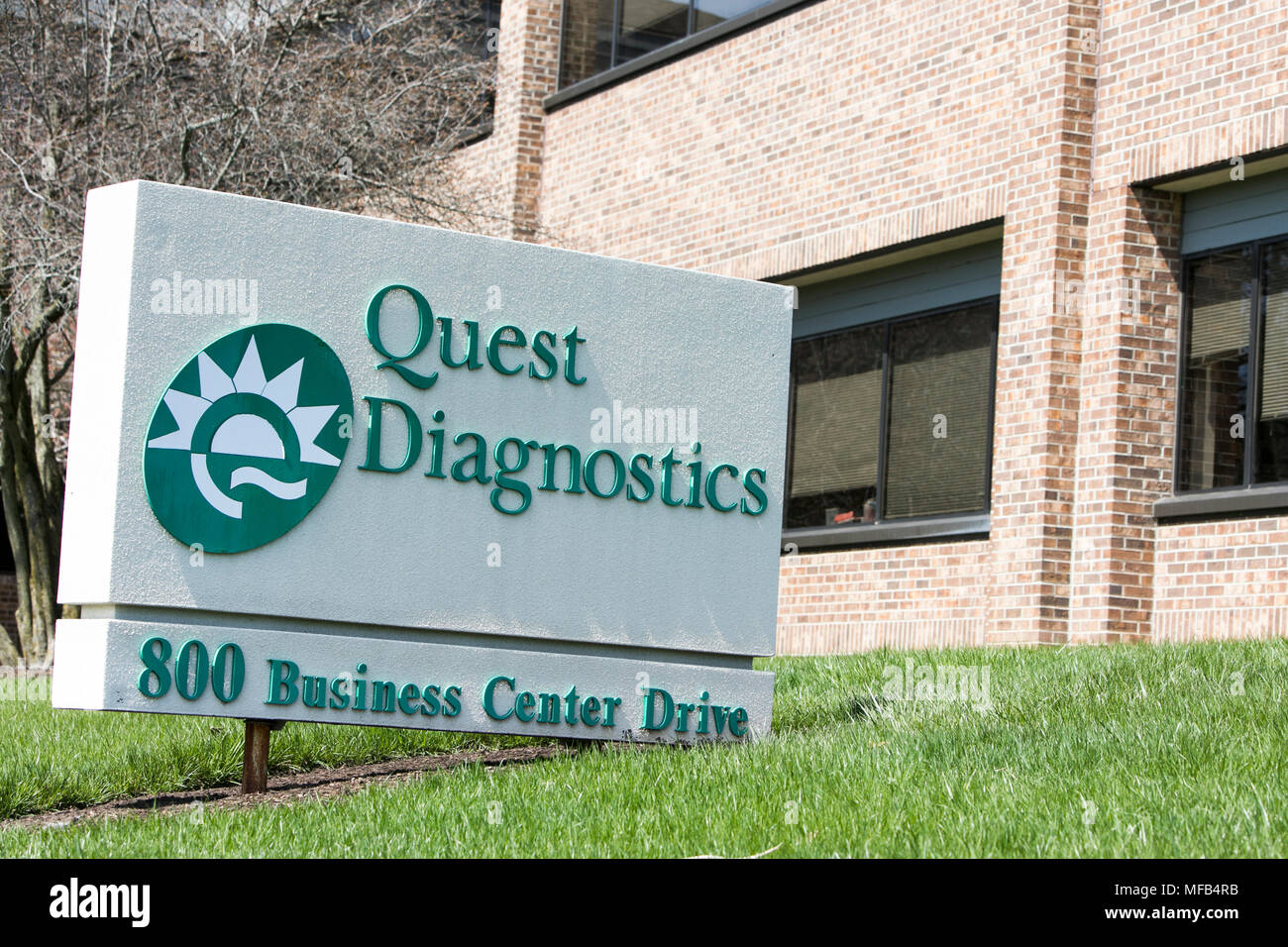 A logo sign outside of a facility occupied by Quest Diagnostics in