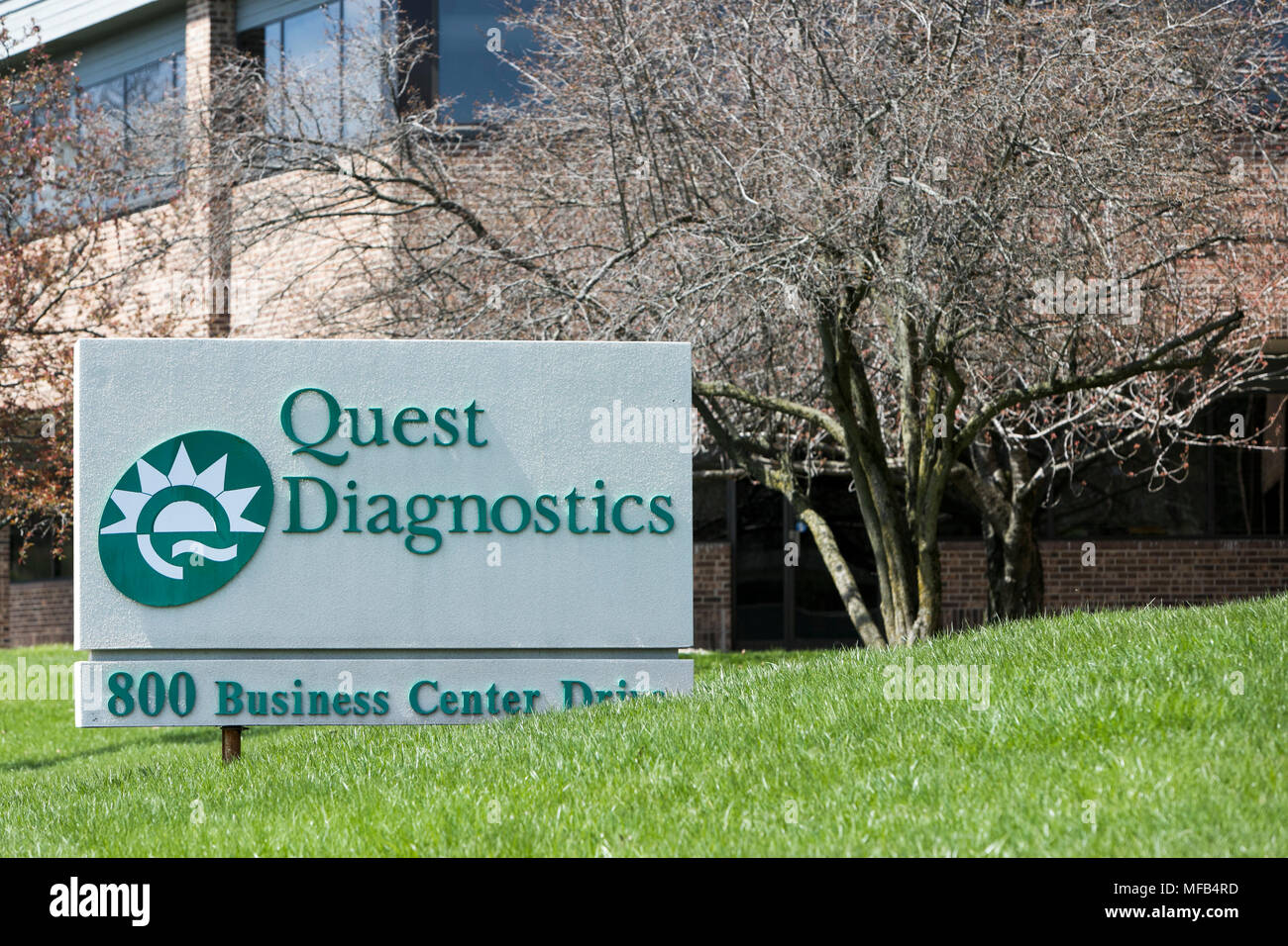 A logo sign outside of a facility occupied by Quest Diagnostics in