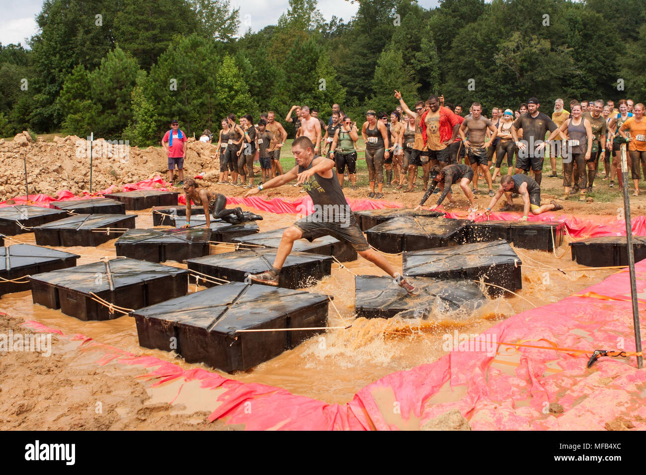 Competitors struggle to maintain their balance running across floating ...