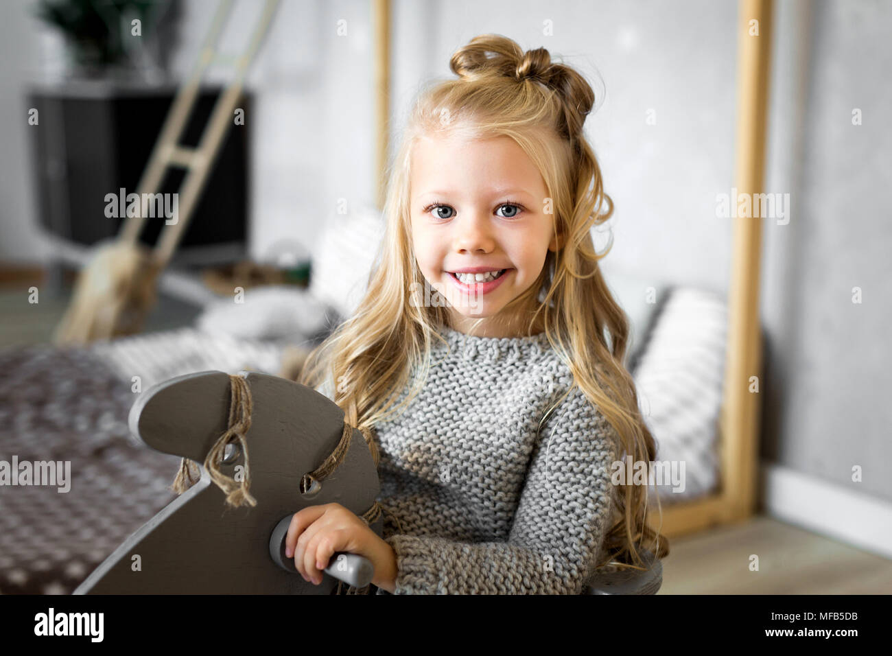 Cute little girl riding a toy horse. Stock Photo