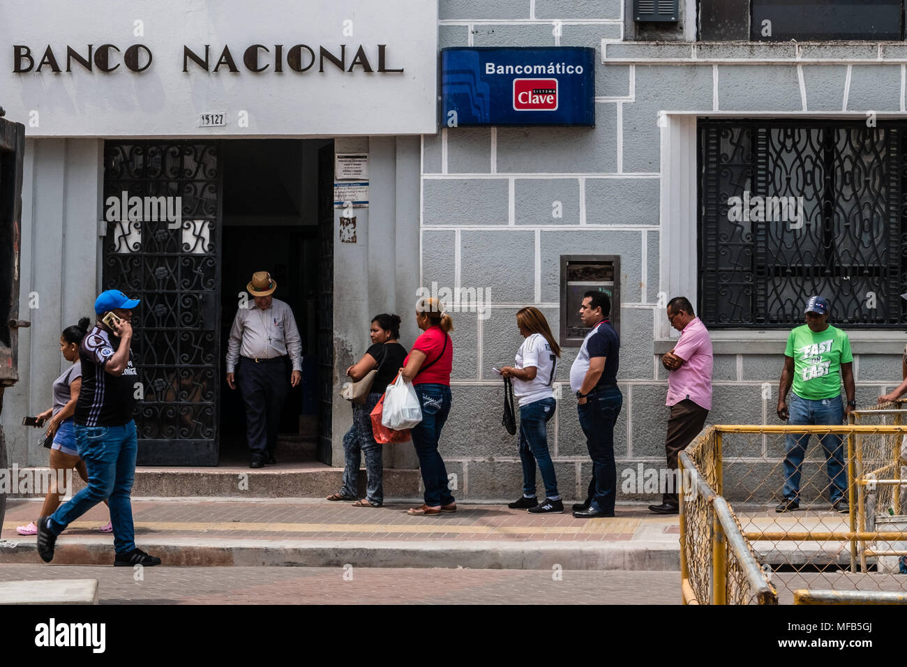 Panama City, Panama - march 2018: Many people standing in queue waiting in front of bank (Banco Nacional) buling in  Panama City Stock Photo