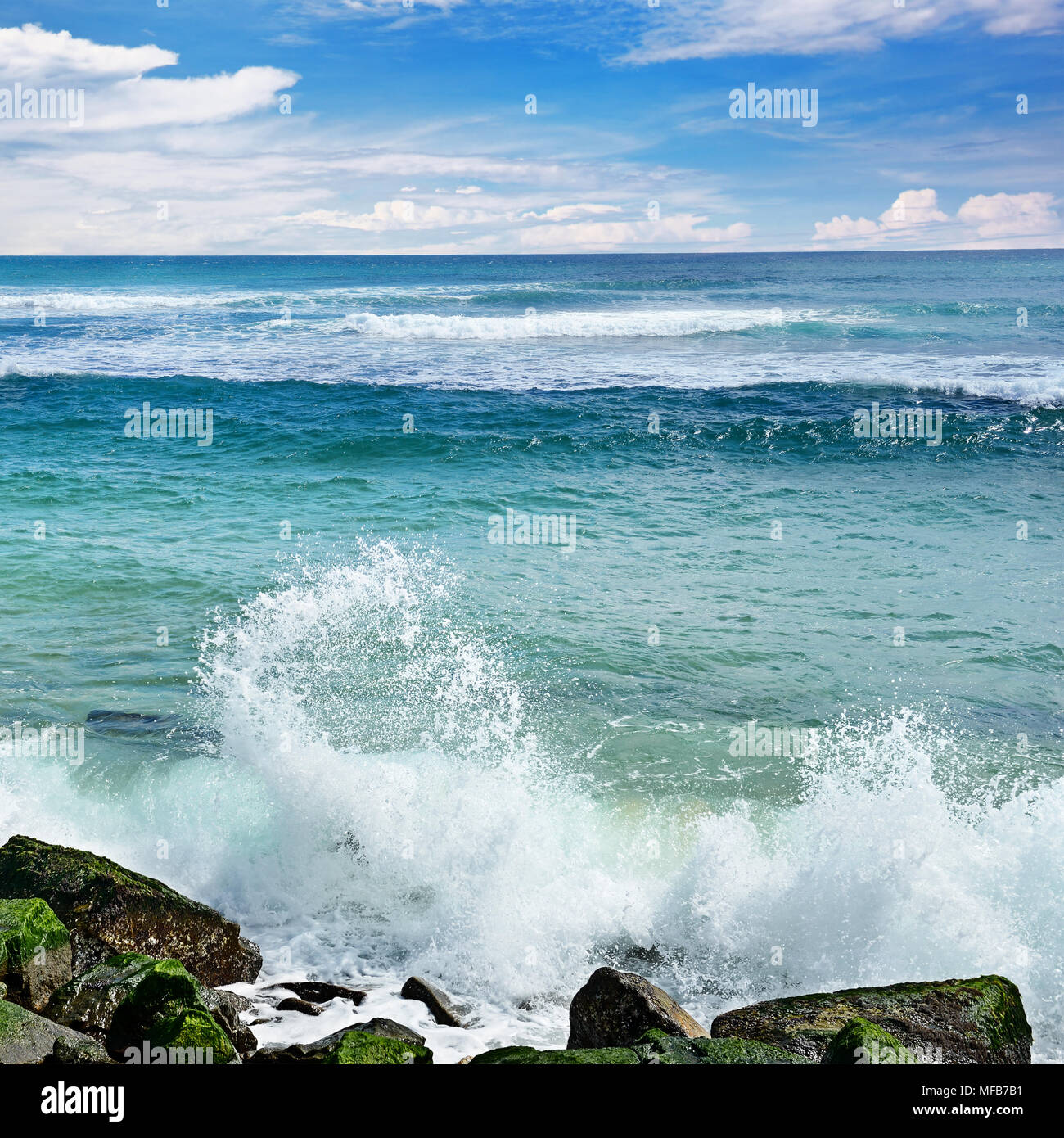 Waves break against stony shore of ocean. Seascape. Stock Photo