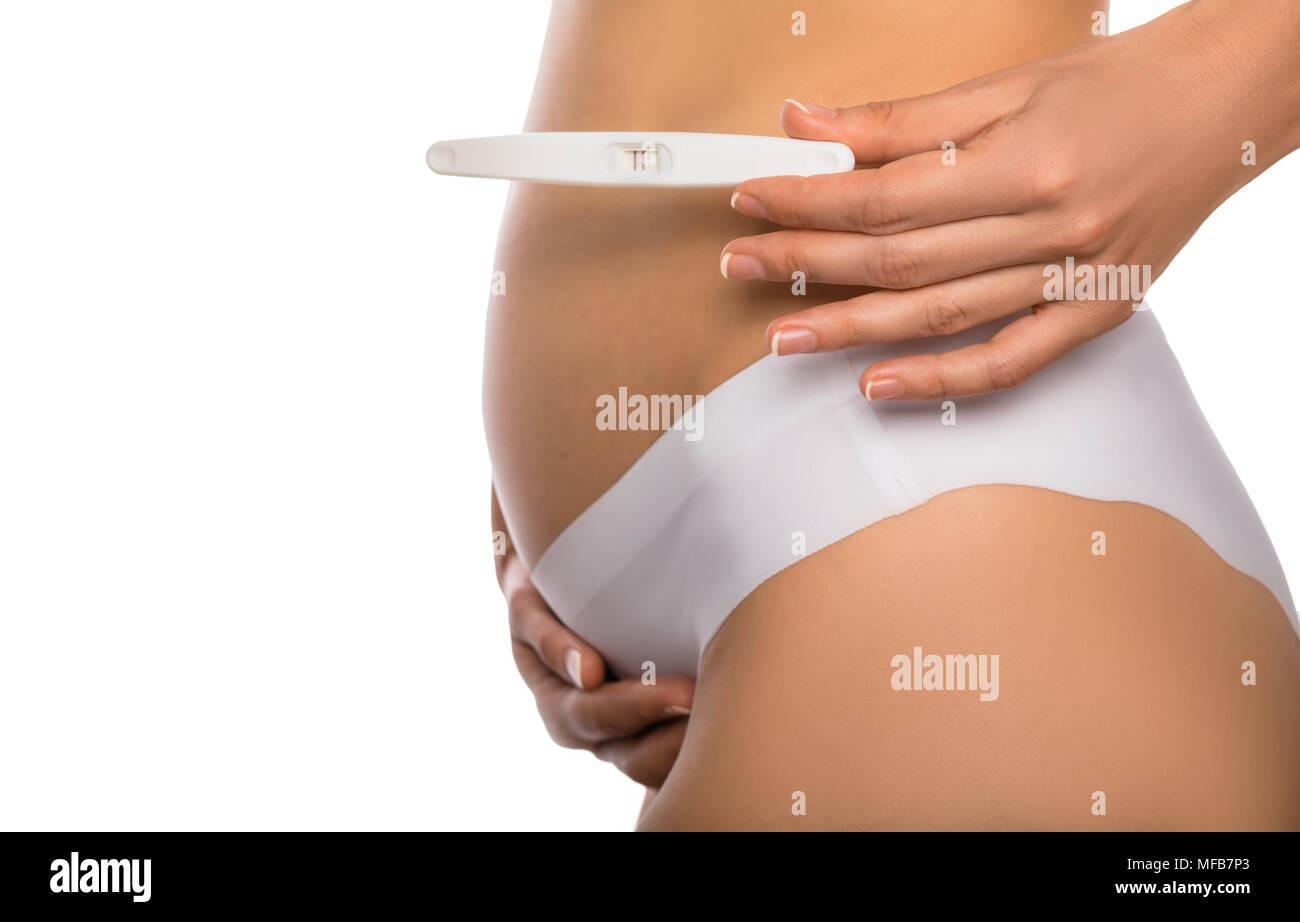 positive pregnancy test against a pregnant abdomen Stock Photo