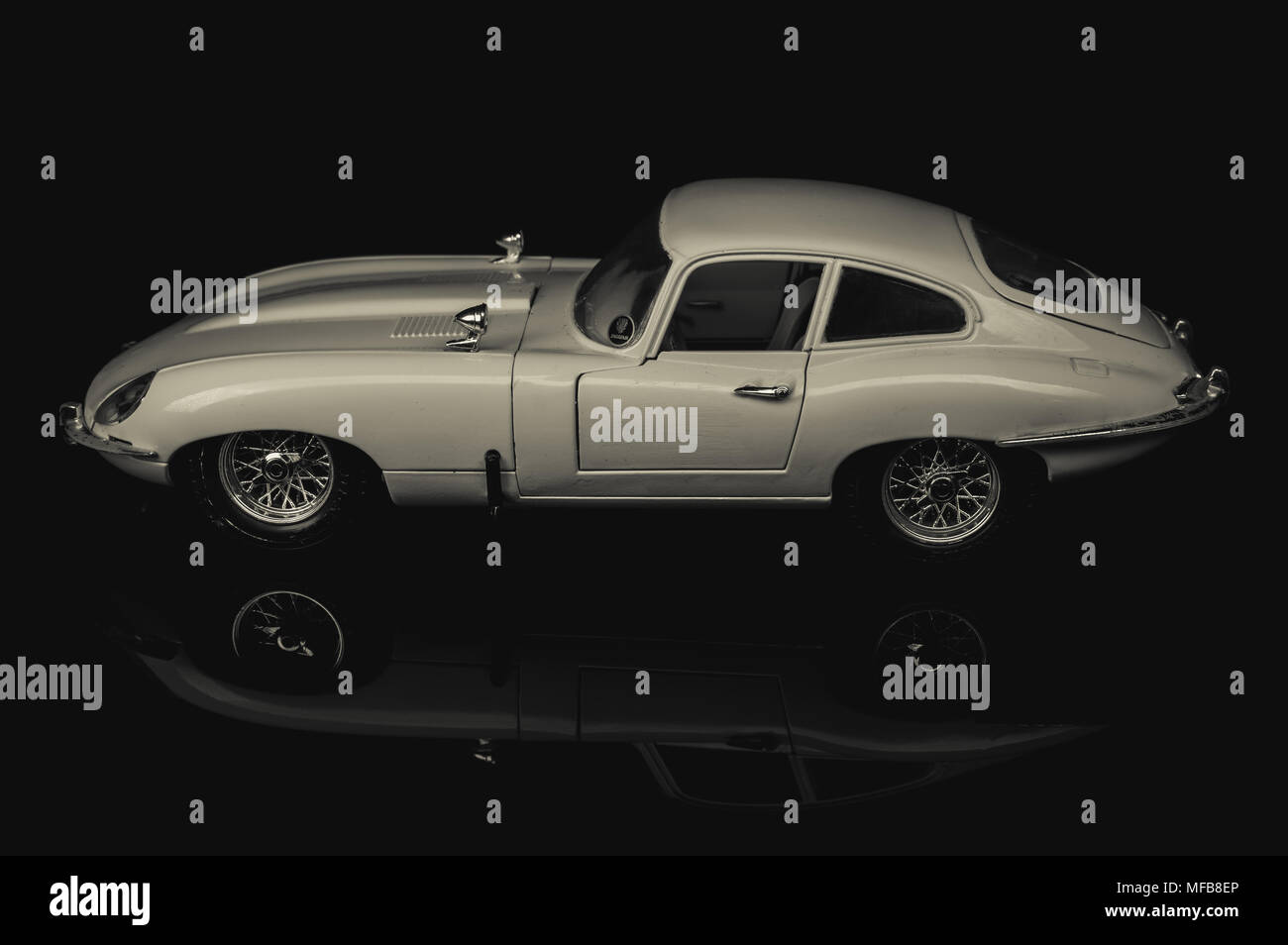 Black and white studio image of a toy Jaguar E type 4.2 coupe classic car. Stock Photo